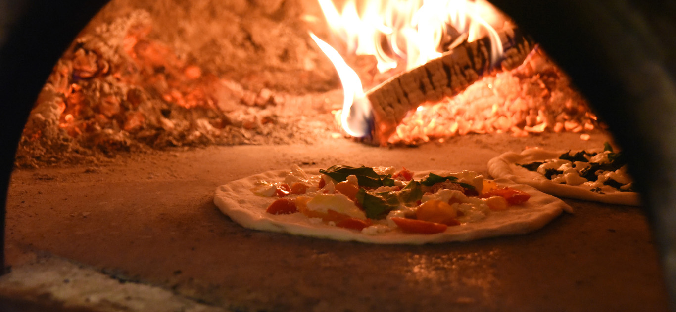 Pizza nel forno a legna